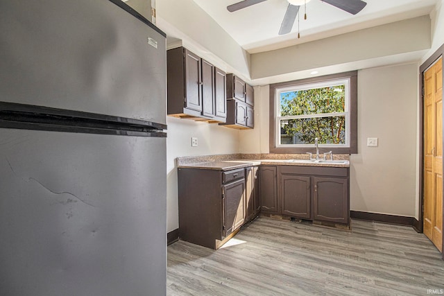 kitchen featuring light hardwood / wood-style floors, stainless steel refrigerator, sink, ceiling fan, and dark brown cabinetry