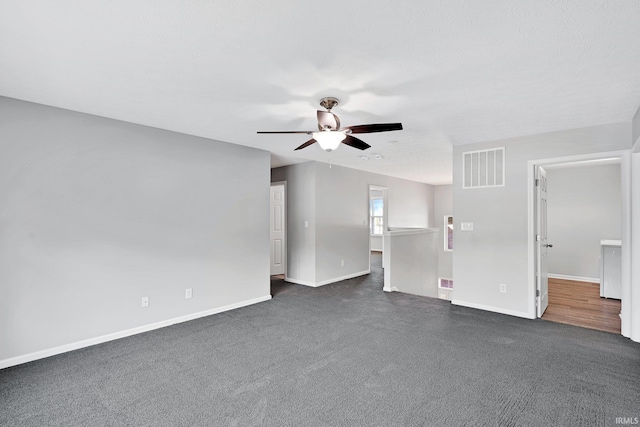 unfurnished living room with ceiling fan and dark colored carpet