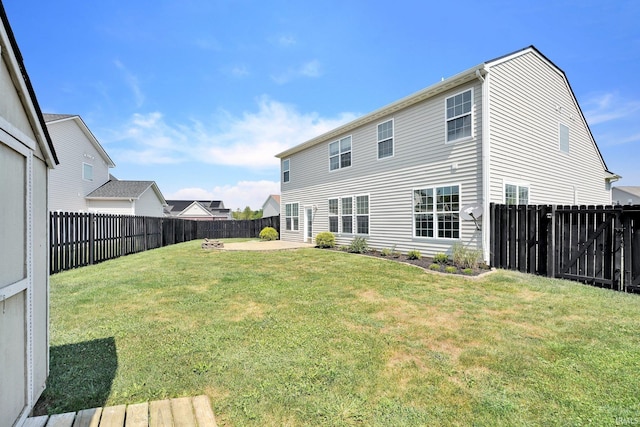 rear view of property featuring a yard, a patio area, and a fenced backyard