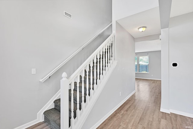 staircase with hardwood / wood-style flooring