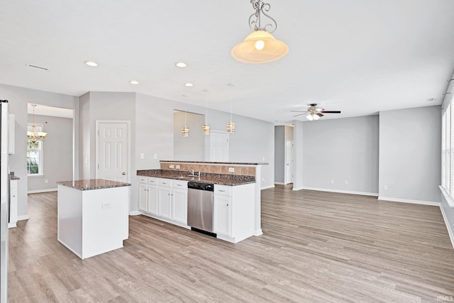 kitchen featuring dishwasher, white cabinetry, hanging light fixtures, dark stone countertops, and a kitchen island