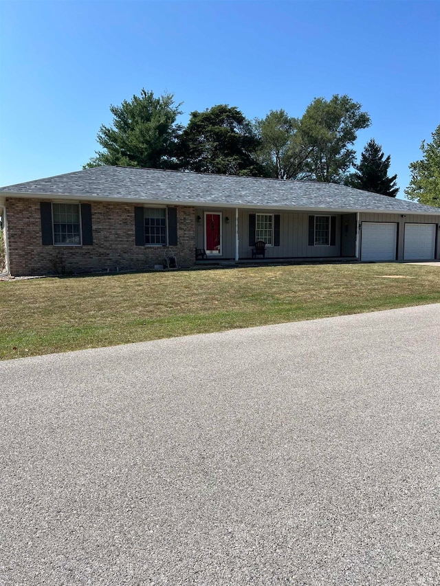 ranch-style home featuring a garage and a front lawn