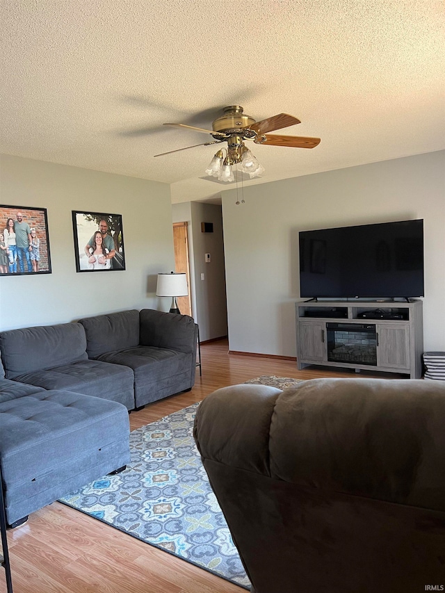 living room featuring a textured ceiling, hardwood / wood-style flooring, and ceiling fan