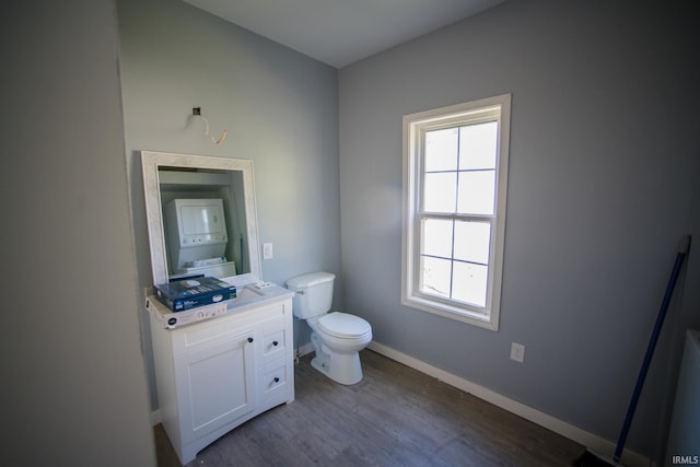 bathroom with baseboards, toilet, wood finished floors, and vanity