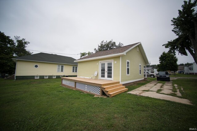 back of house featuring a wooden deck, a lawn, and french doors