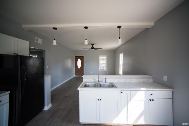 kitchen with visible vents, a peninsula, freestanding refrigerator, white cabinetry, and a sink