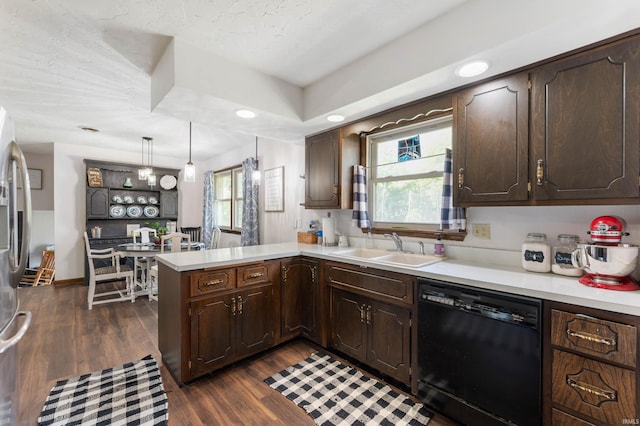 kitchen with dark wood-type flooring, dishwasher, kitchen peninsula, and a healthy amount of sunlight