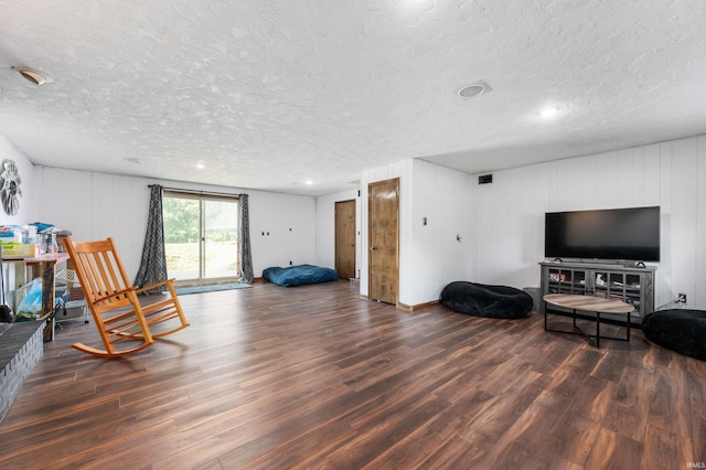 living area with a textured ceiling and dark wood-type flooring