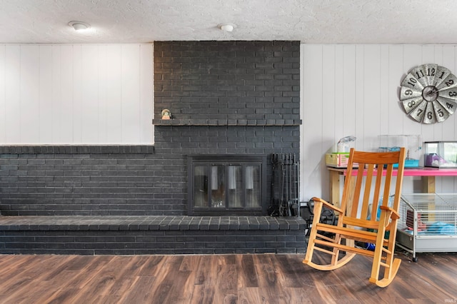 living room with a fireplace, dark hardwood / wood-style floors, and a textured ceiling