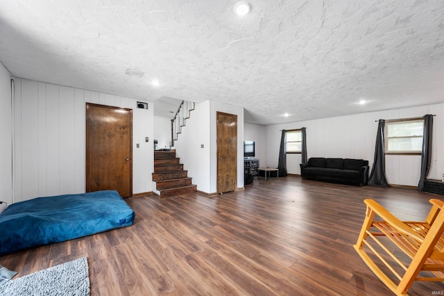 living room with a textured ceiling, a healthy amount of sunlight, and dark hardwood / wood-style floors