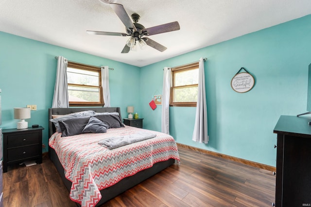 bedroom featuring multiple windows, a textured ceiling, ceiling fan, and dark hardwood / wood-style floors