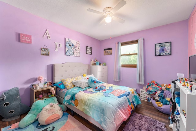 bedroom with a textured ceiling, ceiling fan, and wood-type flooring