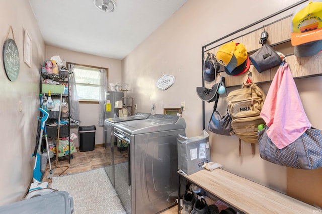 laundry room featuring water heater, washer and clothes dryer, and tile patterned flooring