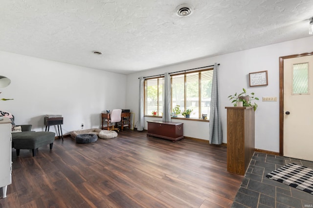 living area featuring a textured ceiling and dark hardwood / wood-style floors