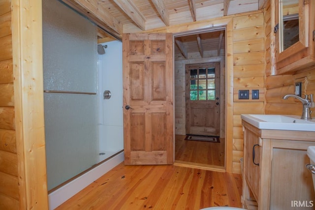 bathroom with wooden ceiling, wood walls, wood finished floors, a shower stall, and beam ceiling