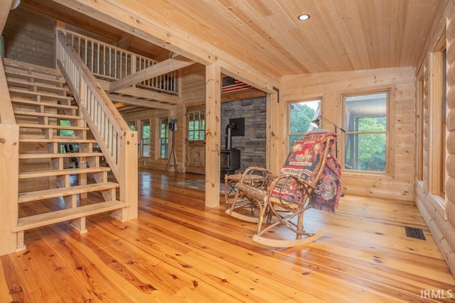 living area featuring wooden ceiling, visible vents, wood-type flooring, and stairs