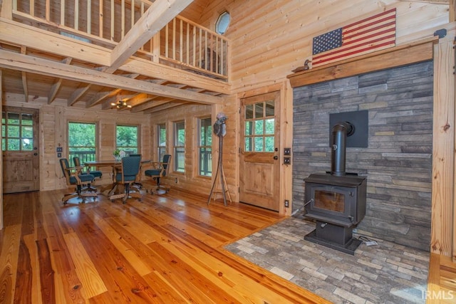 dining room with a wood stove, hardwood / wood-style flooring, and a high ceiling