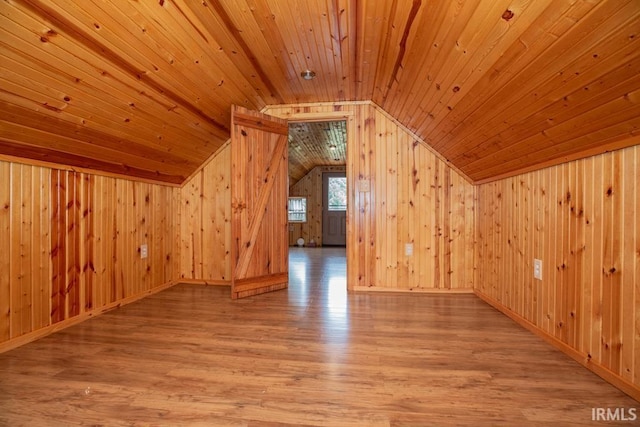 bonus room with lofted ceiling, wood walls, wooden ceiling, and wood finished floors