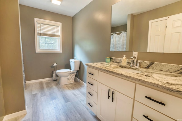 bathroom featuring vanity, toilet, and hardwood / wood-style floors