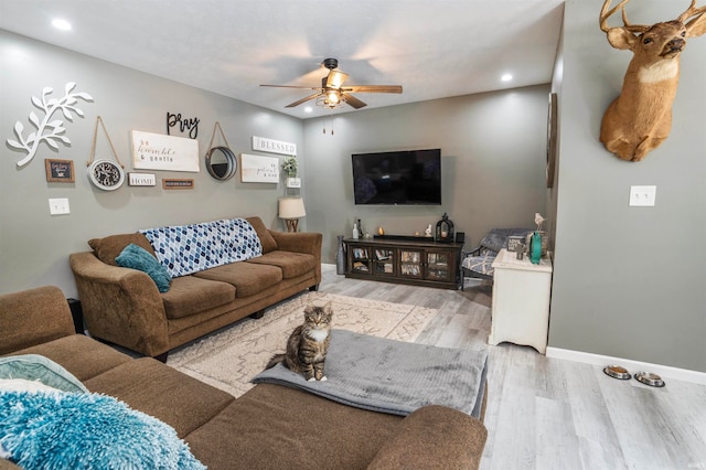 living room with light wood-type flooring and ceiling fan