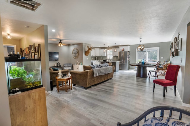 living room featuring light hardwood / wood-style flooring and ceiling fan