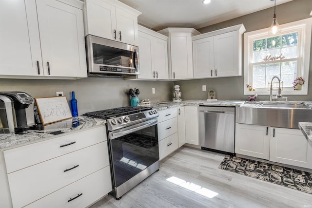 kitchen featuring light hardwood / wood-style flooring, stainless steel appliances, sink, and white cabinetry