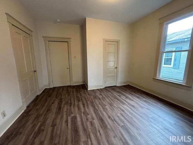 unfurnished bedroom featuring baseboards and wood finished floors