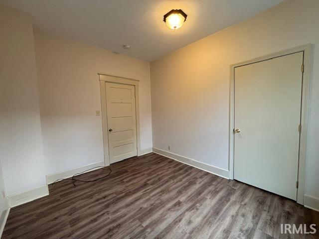 empty room with baseboards and wood finished floors