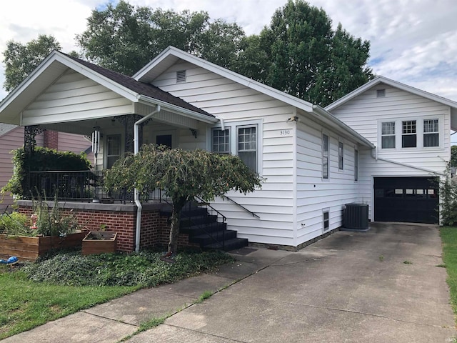 view of front of property with a porch, a garage, and central air condition unit