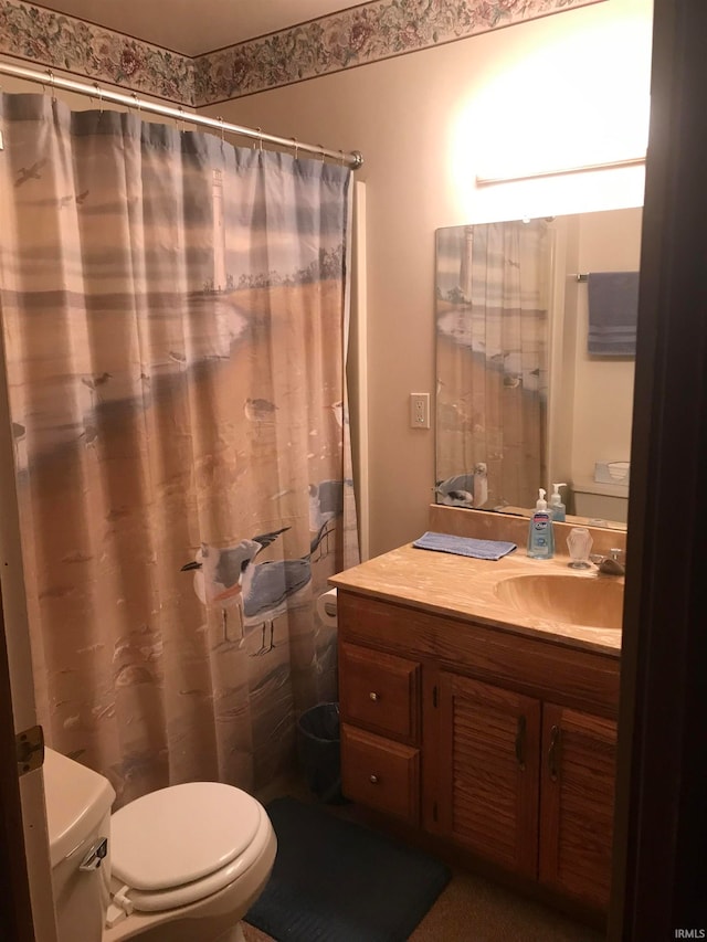 full bath featuring toilet, curtained shower, and vanity