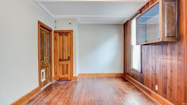 unfurnished room with hardwood / wood-style flooring and crown molding