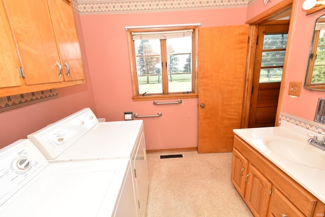 laundry room with light carpet, washer and dryer, and sink