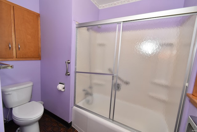 bathroom featuring shower / bath combination with glass door, toilet, and tile patterned floors