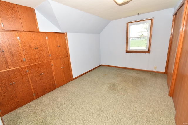 additional living space with lofted ceiling and light carpet