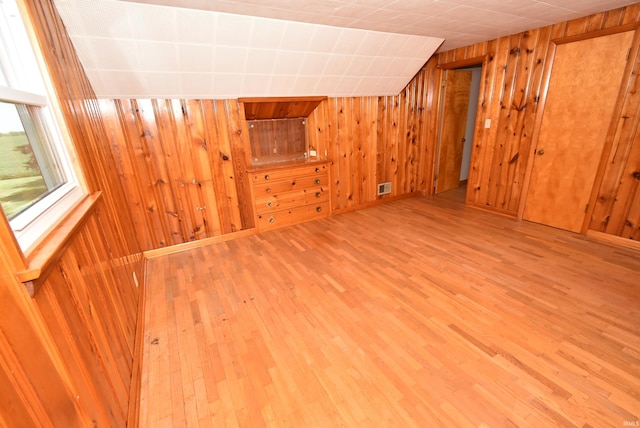 additional living space featuring hardwood / wood-style flooring and wood walls