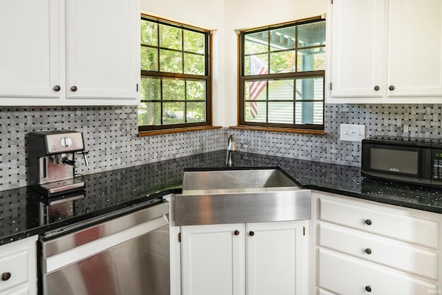 kitchen with white cabinetry, sink, dark stone counters, decorative backsplash, and stainless steel dishwasher