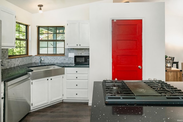 kitchen with white cabinetry, vaulted ceiling, and tasteful backsplash