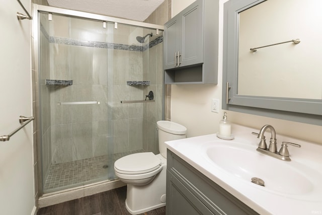 bathroom featuring vanity, toilet, wood-type flooring, and walk in shower