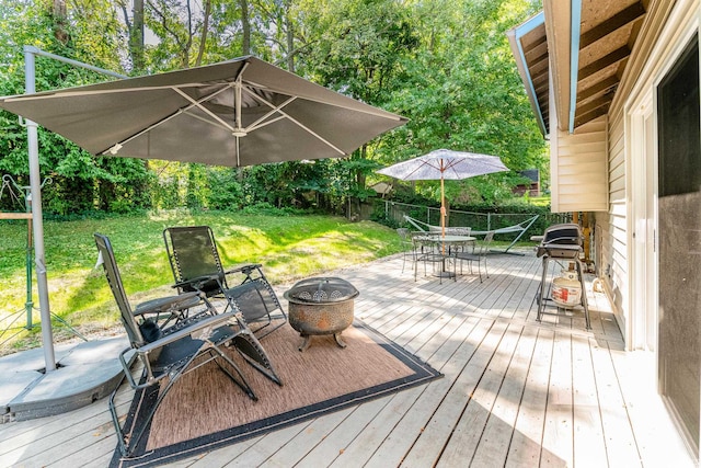 deck featuring a fire pit and a lawn