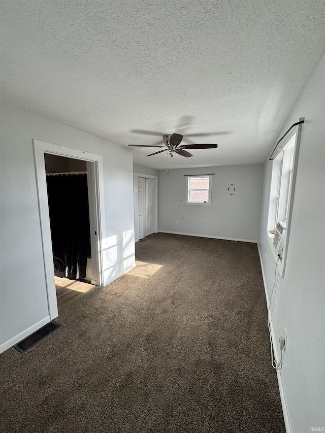 unfurnished room featuring baseboards, visible vents, carpet, cooling unit, and a textured ceiling