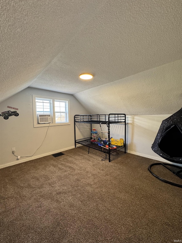 unfurnished bedroom with cooling unit, carpet floors, a textured ceiling, and vaulted ceiling