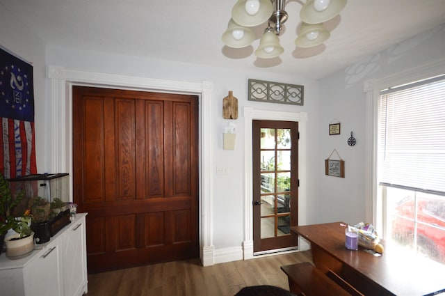 entryway featuring an inviting chandelier and wood finished floors