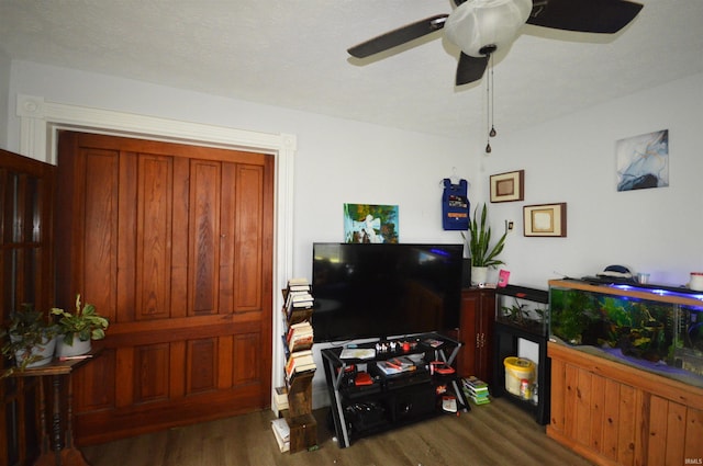 living room featuring dark hardwood / wood-style flooring and ceiling fan