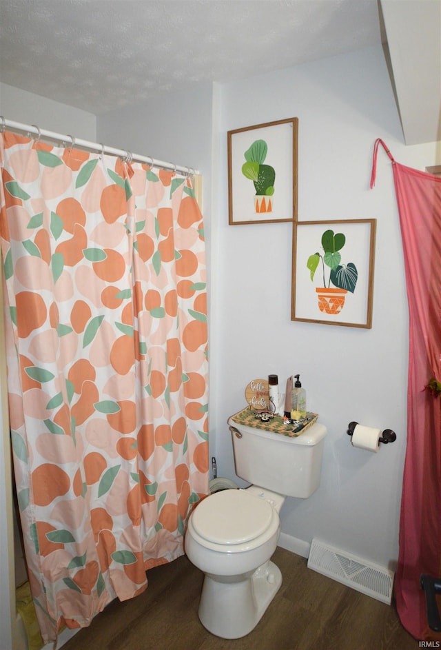 bathroom featuring hardwood / wood-style floors, toilet, and a textured ceiling