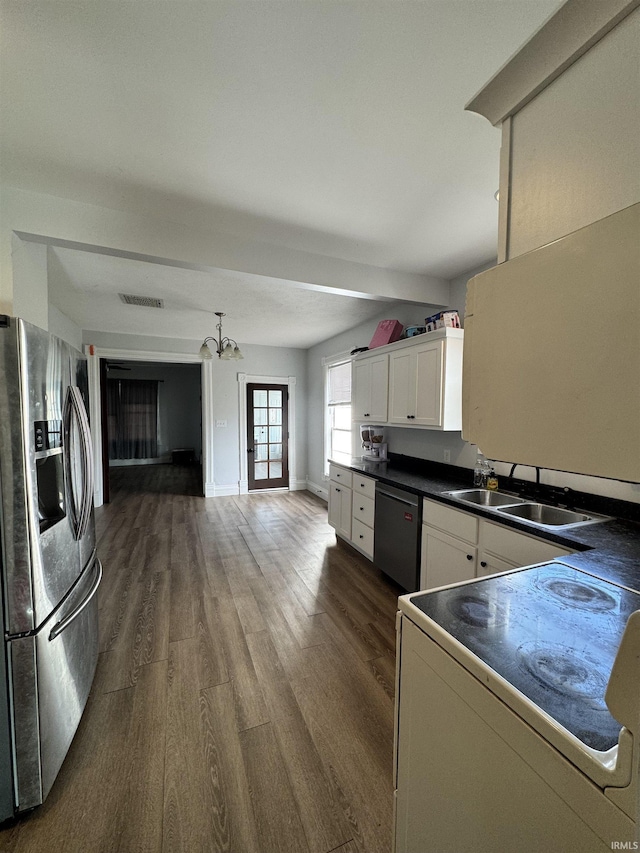 kitchen featuring stainless steel appliances, a sink, visible vents, white cabinets, and dark countertops