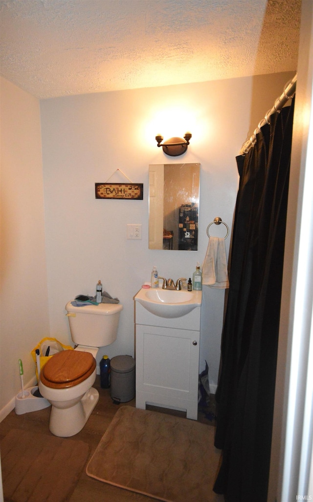 bathroom featuring hardwood / wood-style flooring, vanity, a textured ceiling, and toilet