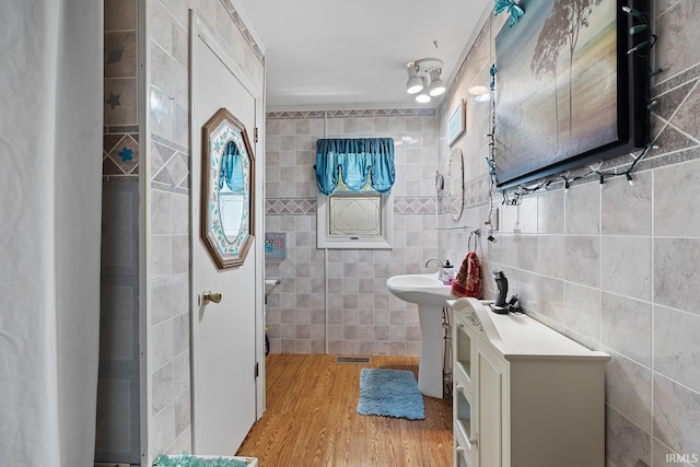 bathroom with tile walls and hardwood / wood-style floors