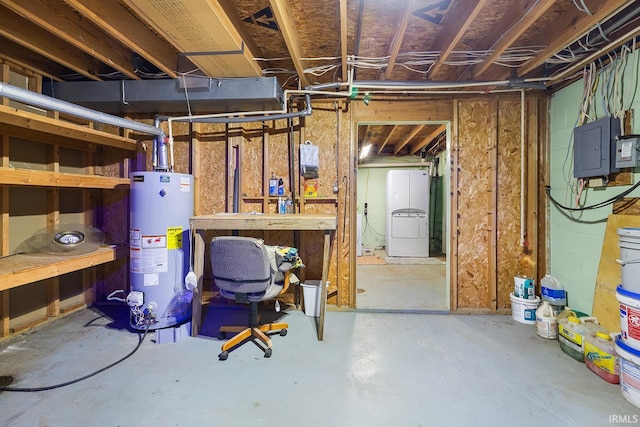 basement with electric panel, a workshop area, and water heater