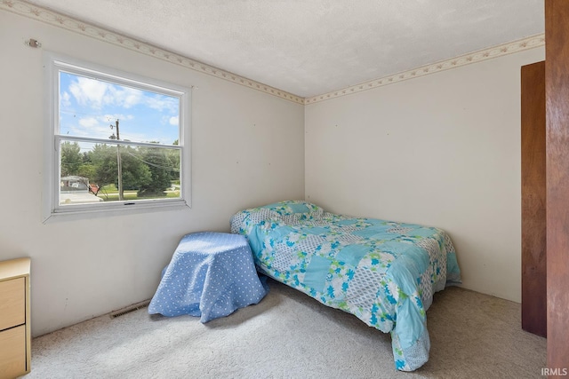 carpeted bedroom featuring multiple windows and a textured ceiling