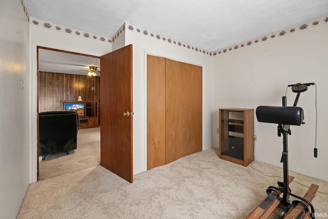 exercise area with light colored carpet and ceiling fan